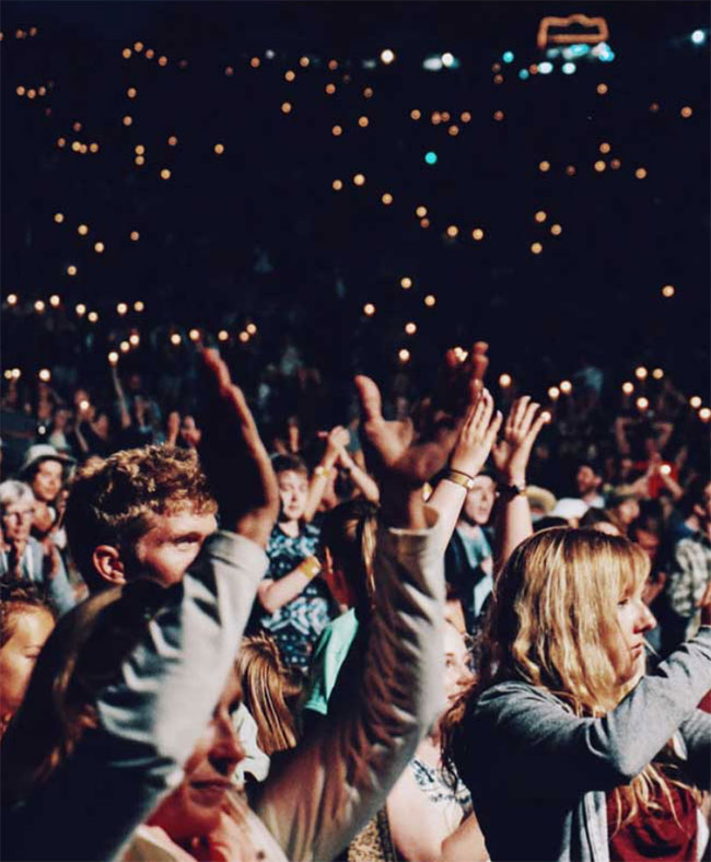 People with arms in the air at a concert